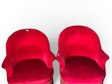 pair of red velvet chairs with fringes on the legs