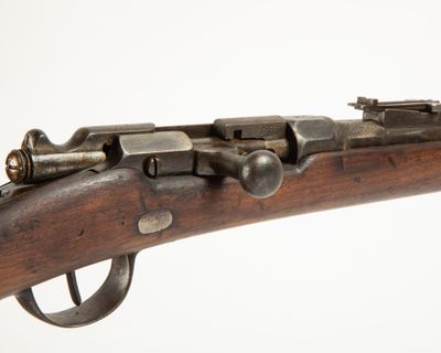 un gros plan d'un fusil sur un fond blanc avec un fond blanc