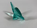 a green glass bird sitting on a white surface
