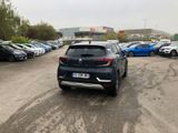 a car parked in a parking lot with other cars in the background