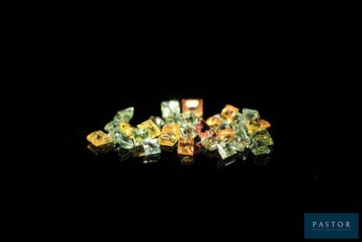 some very pretty colored diamonds on a black surface