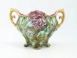 a green vase with a pink flower on it
