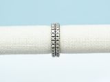 un gros plan sur une serviette blanche sur laquelle repose une bague en argent