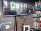 a television that is sitting on a table in front of a refrigerator