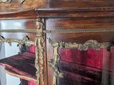 a large wooden cabinet with red velvet on it