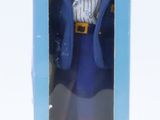 barbie doll in a box on a white surface with a white background