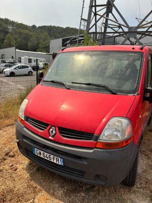 une camionnette rouge garée sur la terre battue