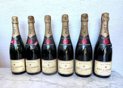 six bouteilles de champagne sont alignées sur une table