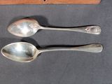 two spoons sitting next to each other on a table