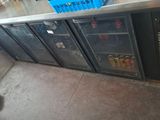 a metal counter with a bunch of bottles on it