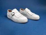 white leather shoes with buckles on a blue background