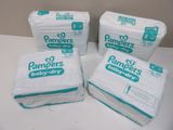 four packs of pampers baby dry diapers sitting on top of a table