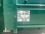 a green truck with a sticker on the back of it