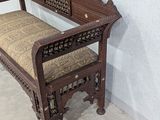 a wooden bench with a cushion on it in the corner of a room