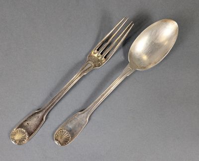 deux cuillères et une fourchette en argent sur une surface grise