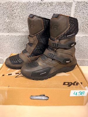 two pairs of boots are sitting on a box in front of a brick wall