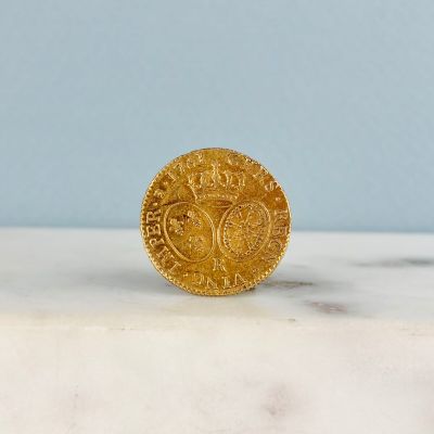 une image représentant une pièce d'or posée sur une surface en marbre