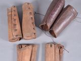 four pairs of leather boots are lined up on a gray surface
