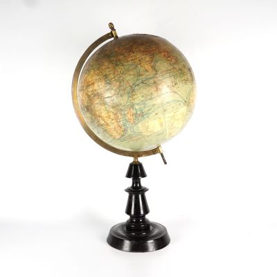 un globe antique posé sur un socle noir, sur fond blanc