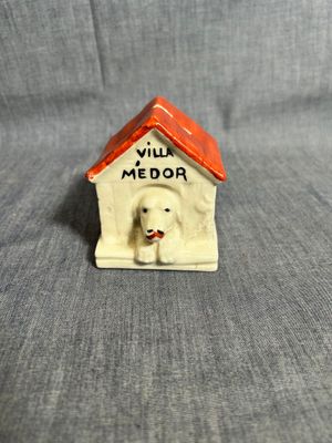 une figurine représentant un chien assis dans une niche