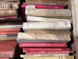 many books stacked on top of each other in a box