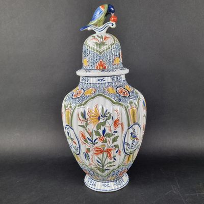 a vase that has a bird on top of it