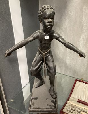 une statue représentant un garçon, exposée dans une vitrine