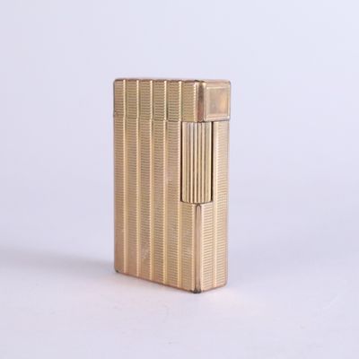 an image of a gold lighter sitting on top of a white surface