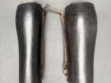 On voit deux paires de chaussures en cuir noir posées sur une surface grise.