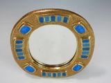an image of a gold and blue mirror on a white surface