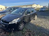 La petite voiture noire est garée sur le parking, à côté d'autres voitures.