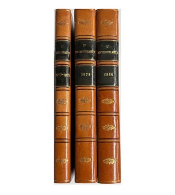 trois livres superposés sur une surface blanche