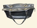 a black purse hanging on a wall with a white background