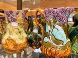 many vases that are on display in a glass case