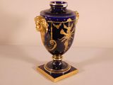 a blue vase with gold decoration on it on a table