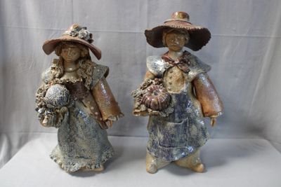 two figurines of a woman and a man holding flowers