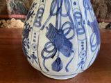 a blue and white vase sitting on a wooden table