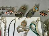 many different types of jewelry displayed on a table