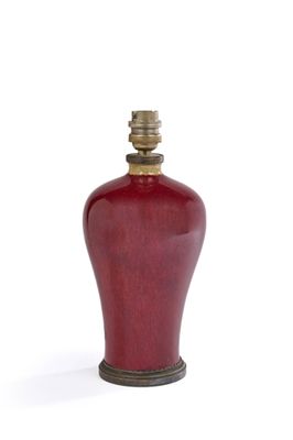 un vase rouge avec un couvercle doré sur fond blanc
