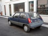 a small blue car parked on the side of the street