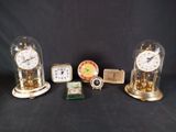 three different clocks and a clock on a table with a black background