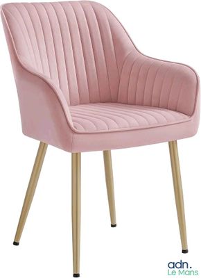 Le fauteuil en velours rose est recouvert de tissu et possède des pieds dorés.