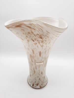 un vase blanc et marron posé sur une surface blanche