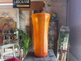a large orange vase sitting on top of a table
