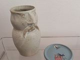 un vase et une assiette exposés dans une vitrine