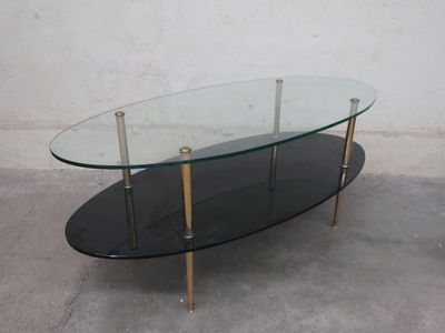 a glass coffee table with brass legs and a glass top