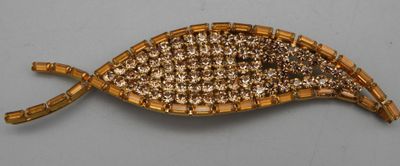 une broche de couleur dorée ornée d'un motif tressé