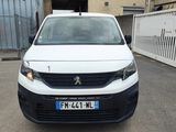 la petite camionnette blanche est garée devant un bâtiment
