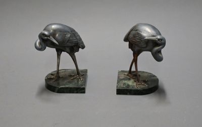 pair of bronze sculptures of two birds on a marble base