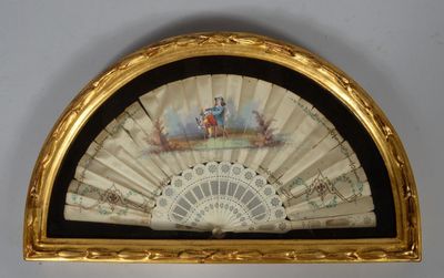 un vieux ventilateur orné d'une peinture, accroché au mur